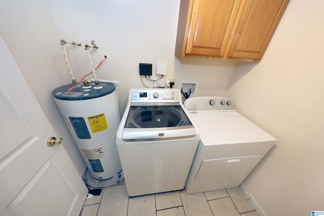 washroom featuring separate washer and dryer, cabinets, electric water heater, and light tile patterned flooring