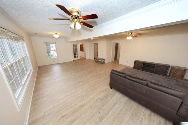 living room with ceiling fan, crown molding, a textured ceiling, and light wood-type flooring