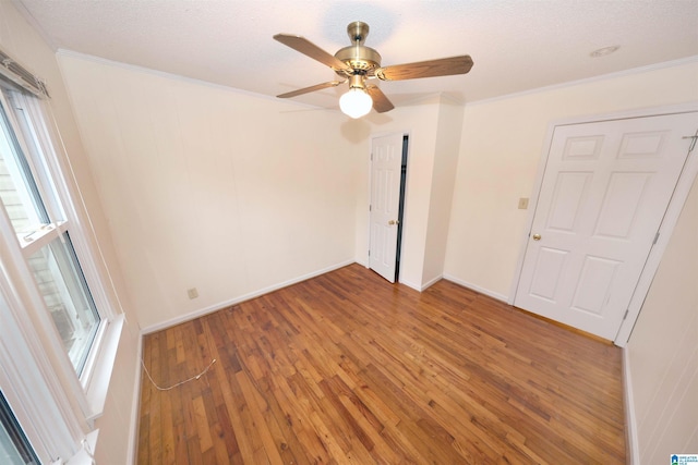 unfurnished bedroom featuring crown molding, hardwood / wood-style floors, and multiple windows