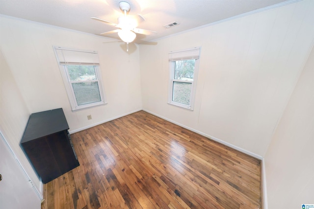 empty room featuring hardwood / wood-style flooring, ceiling fan, and ornamental molding