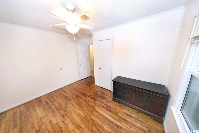 unfurnished bedroom with ceiling fan, ornamental molding, dark hardwood / wood-style floors, and a textured ceiling