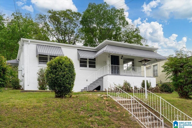 view of front of property featuring covered porch and a front lawn