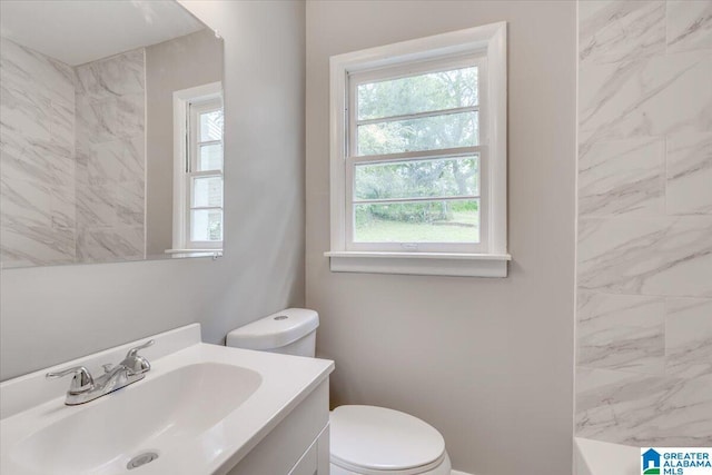 bathroom featuring vanity, a tile shower, and toilet