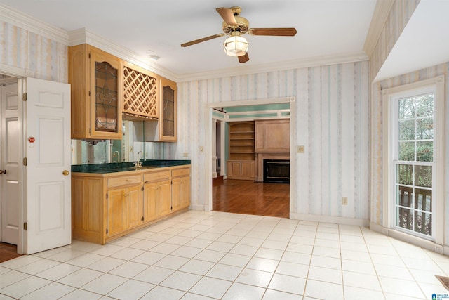 kitchen with ceiling fan, ornamental molding, sink, and light tile patterned floors