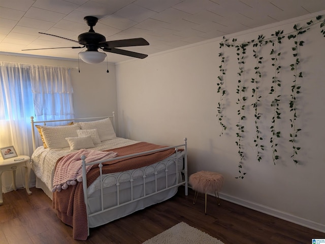 bedroom featuring crown molding, dark hardwood / wood-style floors, and ceiling fan