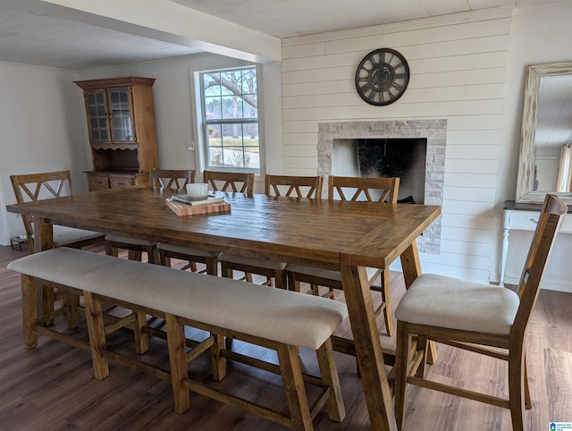 dining space with dark hardwood / wood-style floors and wood walls