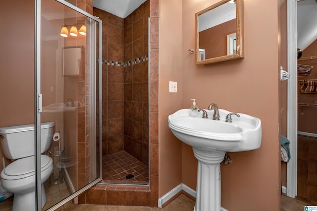 bathroom featuring an enclosed shower, tile patterned floors, and toilet