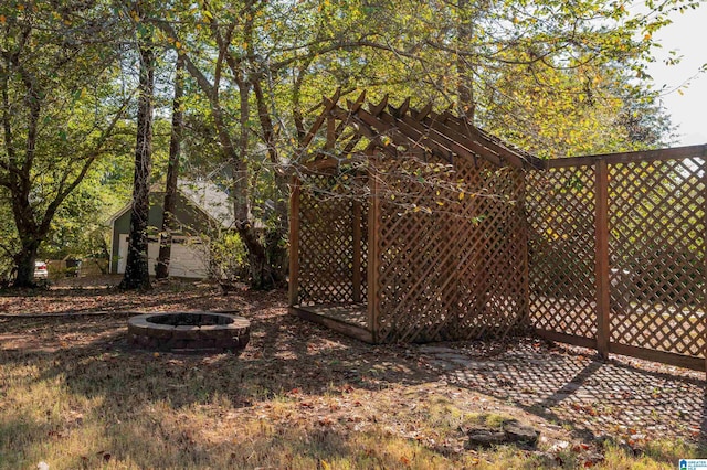 view of yard featuring an outdoor structure and an outdoor fire pit