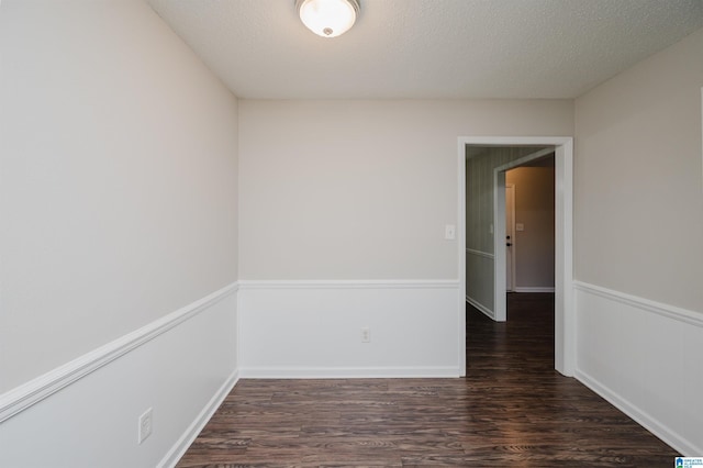 unfurnished room with dark hardwood / wood-style floors and a textured ceiling