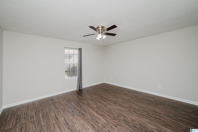 empty room with ceiling fan, dark wood-type flooring, and a textured ceiling