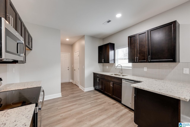 kitchen featuring dark brown cabinets, stainless steel appliances, sink, and light hardwood / wood-style flooring