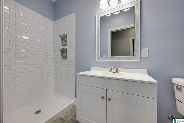 bathroom with vanity and a tile shower