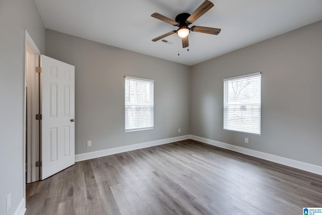 empty room featuring ceiling fan, plenty of natural light, and light hardwood / wood-style floors