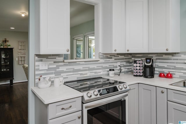 kitchen with white cabinetry, electric range, dark hardwood / wood-style flooring, and decorative backsplash