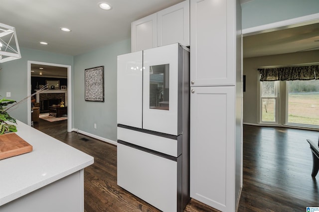 kitchen with fridge, white cabinets, and dark hardwood / wood-style flooring