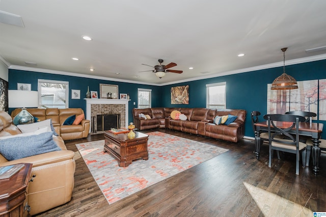 living room featuring a brick fireplace, crown molding, dark hardwood / wood-style floors, and ceiling fan