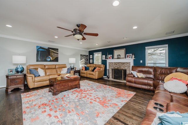 living room featuring dark hardwood / wood-style flooring, a brick fireplace, ornamental molding, and ceiling fan