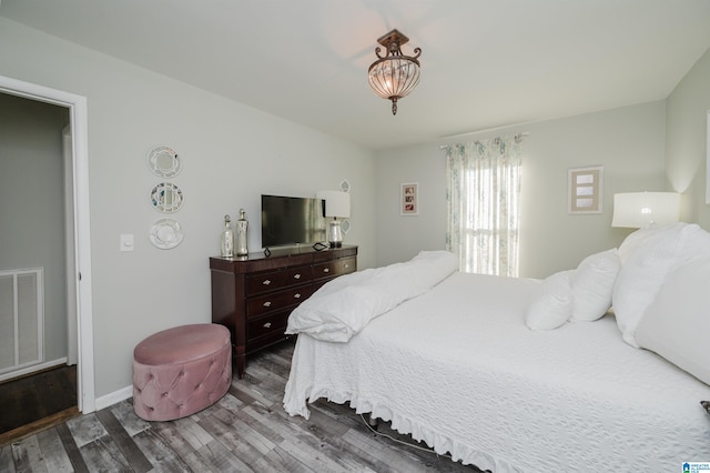 bedroom with dark hardwood / wood-style flooring