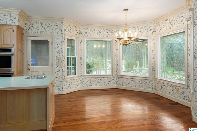 unfurnished dining area featuring hardwood / wood-style flooring, crown molding, and sink