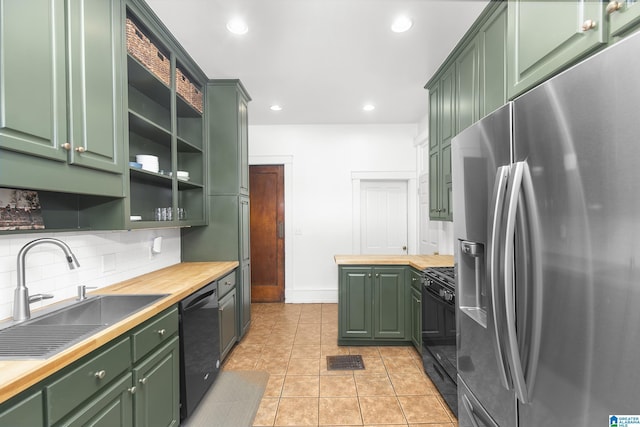 kitchen featuring sink, green cabinets, wooden counters, and black appliances