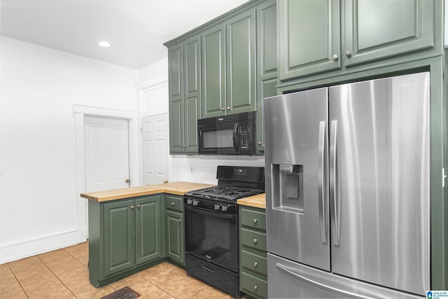 kitchen featuring light tile patterned flooring, black appliances, wooden counters, backsplash, and green cabinetry