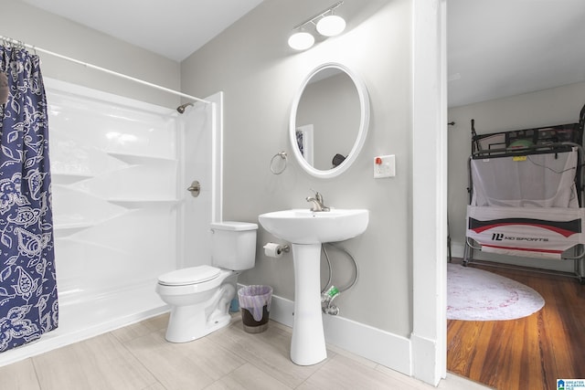 bathroom with sink, curtained shower, and toilet