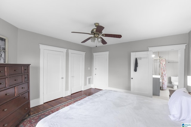 bedroom featuring multiple closets, wood-type flooring, and ceiling fan