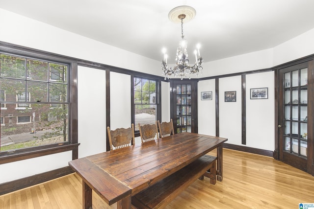 dining area with a chandelier and light hardwood / wood-style flooring