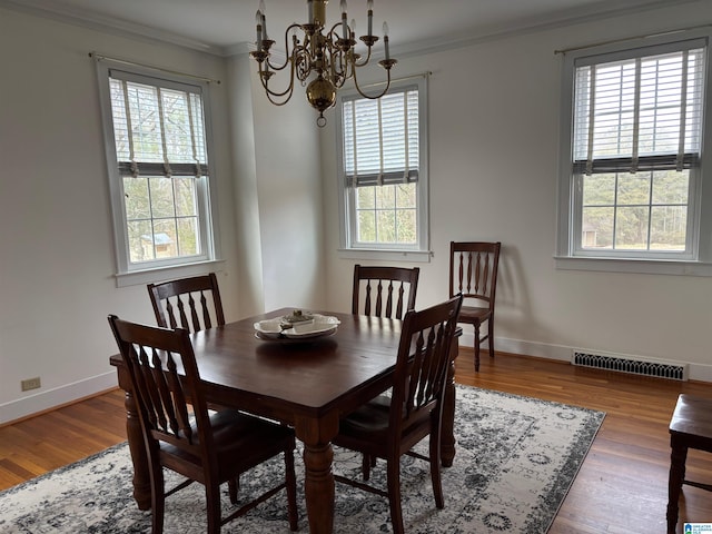 dining area featuring ornamental molding, a wealth of natural light, and hardwood / wood-style floors