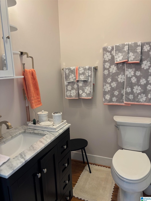 bathroom with hardwood / wood-style flooring, vanity, and toilet