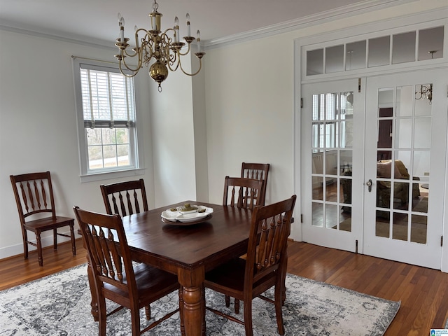 dining area with french doors, ornamental molding, hardwood / wood-style floors, and a notable chandelier