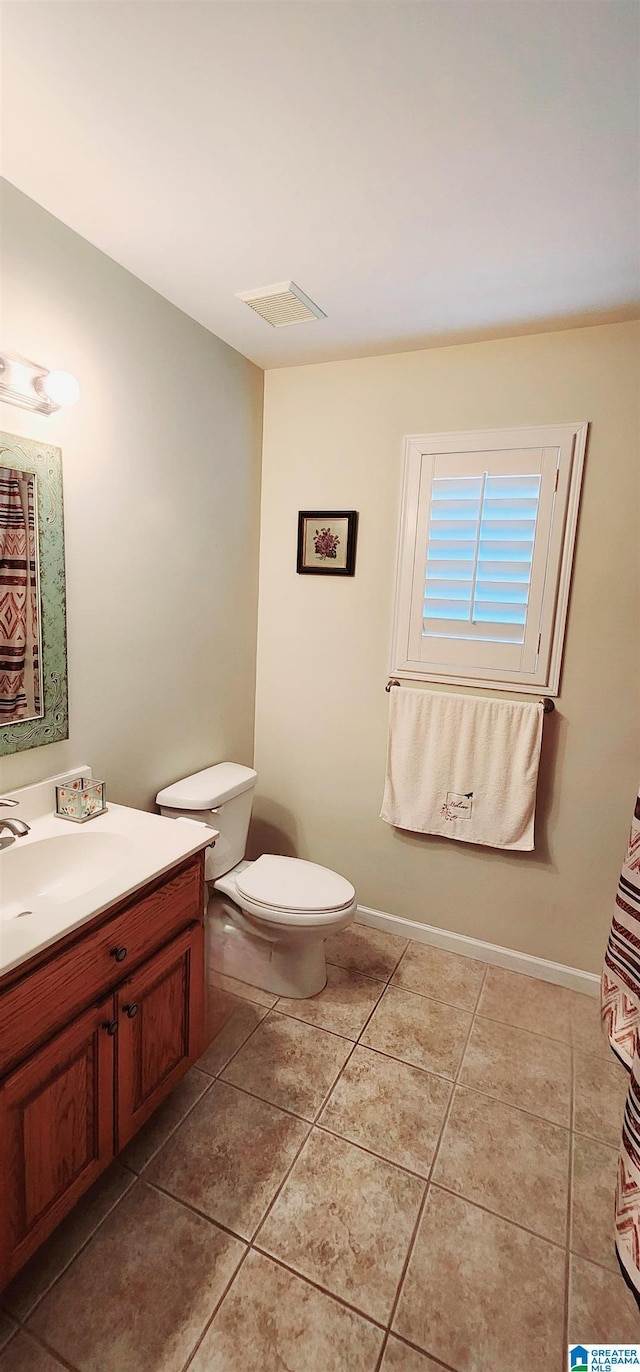 bathroom featuring vanity, tile patterned floors, and toilet