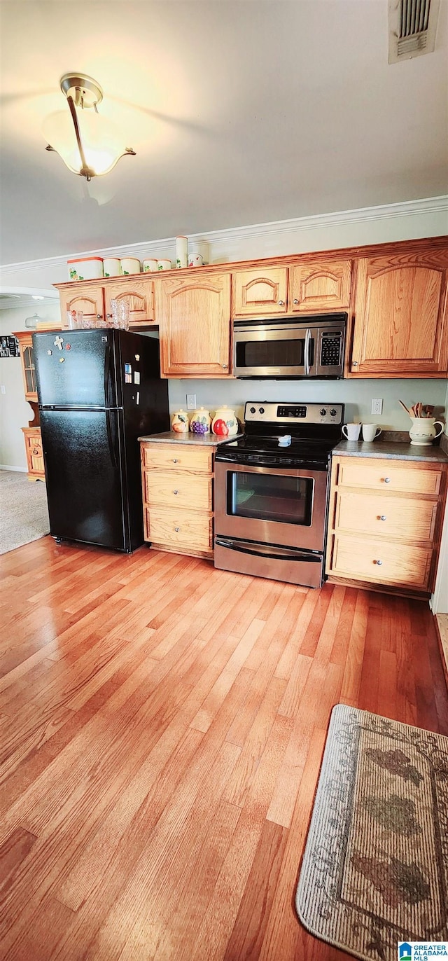 kitchen featuring appliances with stainless steel finishes, light brown cabinets, and light hardwood / wood-style floors