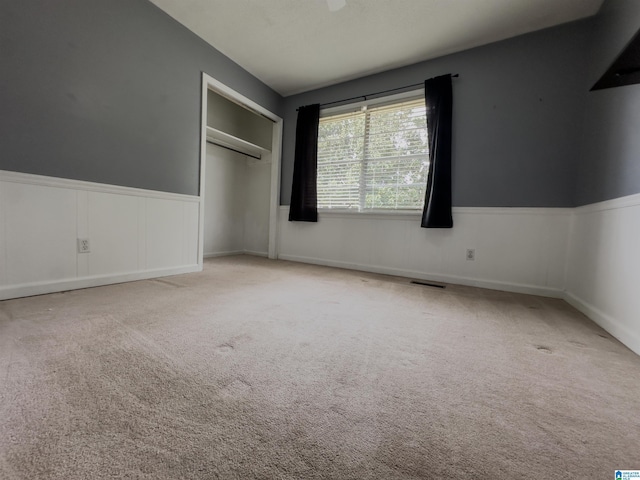 unfurnished bedroom with light carpet and a closet