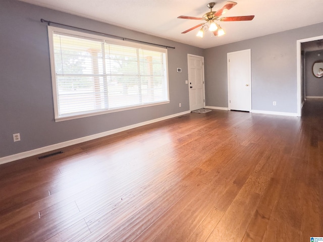 empty room with dark wood-type flooring and ceiling fan