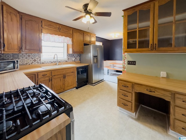 kitchen with appliances with stainless steel finishes, sink, ceiling fan, and decorative backsplash