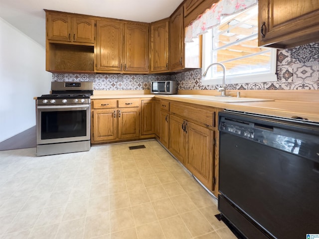 kitchen with tasteful backsplash, appliances with stainless steel finishes, and sink