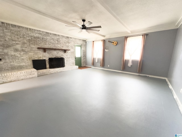 unfurnished living room featuring ceiling fan, brick wall, a textured ceiling, and a fireplace