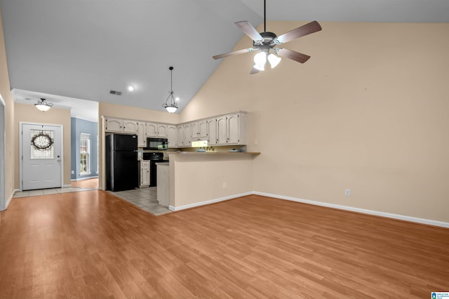 kitchen with white cabinetry, light hardwood / wood-style flooring, kitchen peninsula, and black appliances