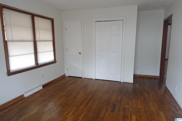 unfurnished bedroom featuring a baseboard radiator and dark hardwood / wood-style flooring