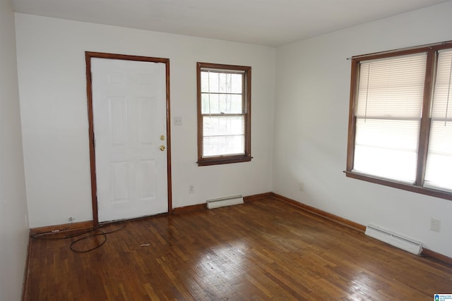 unfurnished room featuring dark hardwood / wood-style flooring and a baseboard heating unit