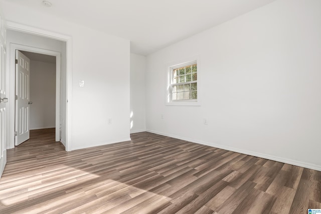 unfurnished room with dark hardwood / wood-style flooring