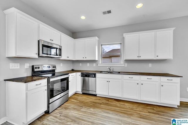 kitchen with white cabinetry, sink, light hardwood / wood-style flooring, and stainless steel appliances