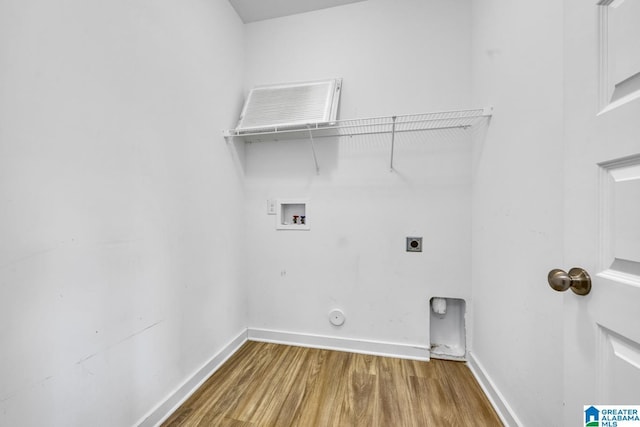 clothes washing area with hardwood / wood-style flooring, hookup for an electric dryer, washer hookup, and hookup for a gas dryer