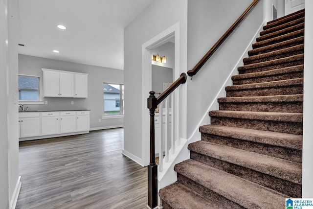 stairway with hardwood / wood-style flooring and sink