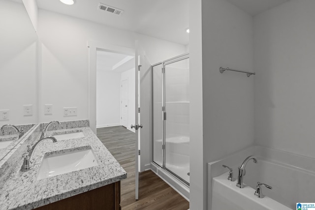 bathroom featuring hardwood / wood-style flooring, vanity, and independent shower and bath