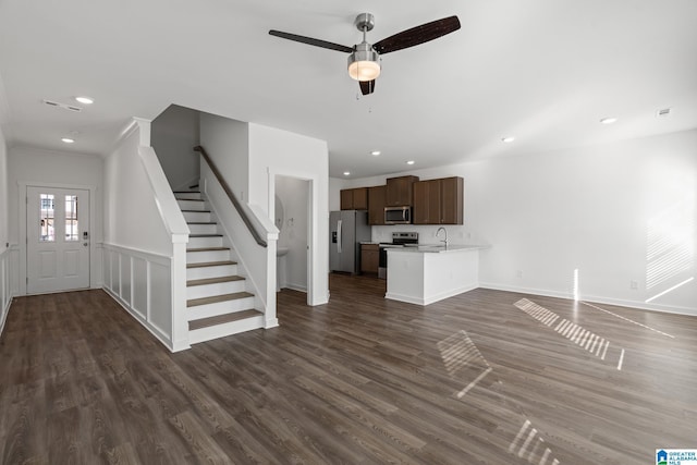 unfurnished living room with dark wood-type flooring, ceiling fan, and sink