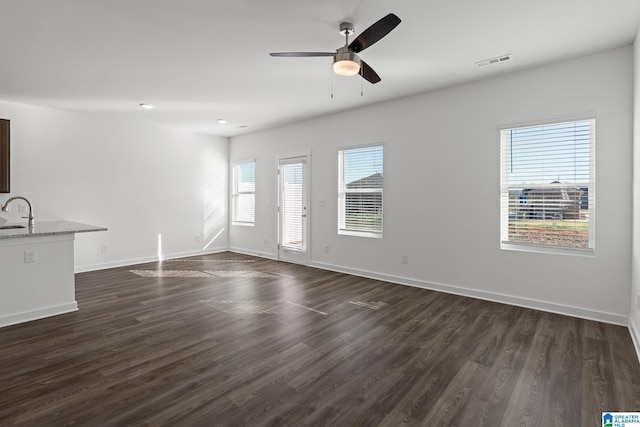 unfurnished living room featuring sink, dark wood-type flooring, and ceiling fan