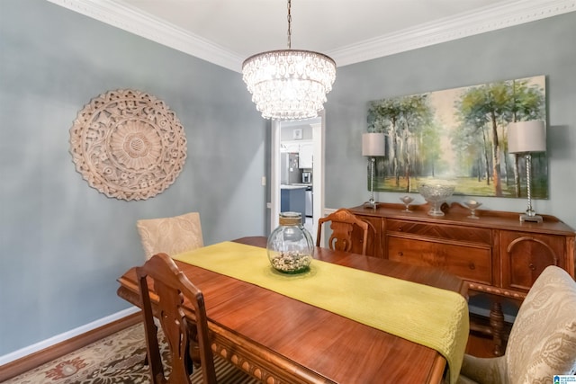 dining space featuring crown molding, hardwood / wood-style floors, and an inviting chandelier