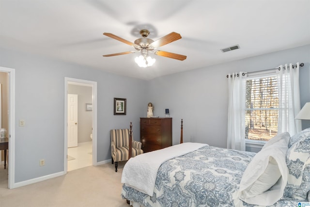 bedroom with ceiling fan, connected bathroom, and light carpet